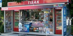 a store front with various items on display in the window, and an advertisement for it'sak