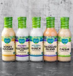 four bottles of ranch dressing are lined up in a row on a counter top,