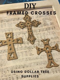 three wooden crosses sitting on top of an old sheet of paper with the words, diy framed crosses using dollar tree supplies