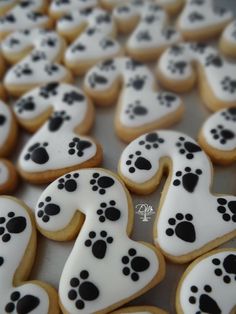 decorated cookies with white icing and black dog paw prints on them are arranged in the shape of hearts