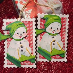 two snowmen on red and white christmas cards with twine string attached to them