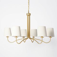 a chandelier with five lamps hanging from it's sides and four shades on each side