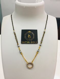 a necklace on display with a tag that says satva gold