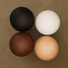 three different colored balls sitting next to each other on the floor in an overhead view