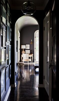 an archway leading to a dining room with pictures on the wall and table in between