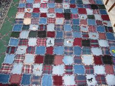 an old patchwork quilt is laying on the ground in front of a chair and table