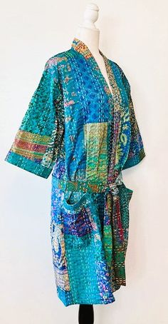 This delightful kimono is a breath of fresh air. A full kaleidoscope of bright colors like a blooming spring garden. Constructed with high quality cotton, handmade and kantha embroidered. Designed as a traditional short kimono with an extra wide front band showcasing kantha embroidery created by hand. This embroidery is also carried throughout the garment. Special detailing is noticable throughout the garment, double width hem panel, etc. The bright color pallet works well with most skin tones. Blue Cotton Kimono For Festival, Blue Floral Embroidered Kimono For Spring, Bohemian Blue Kimono With Floral Embroidery, Blue Bohemian Kimono With Floral Embroidery, Blue Bohemian Kimono With Patchwork, Embroidered Multicolor Summer Kimono, Handmade Multicolor Cotton Kimono, Multicolor Cotton Kimono With Floral Embroidery, Summer Embroidered Folk Kimono