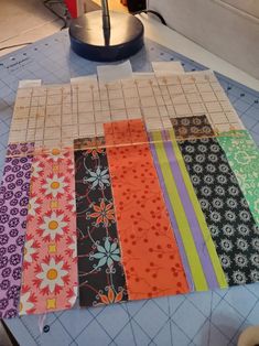 a table topped with lots of different types of fabrics on top of a cutting board