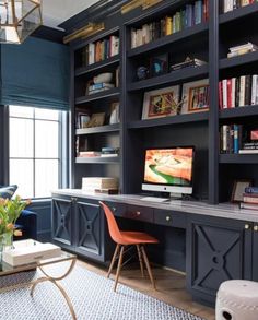 a home office with built - in bookshelves, desk and computer on it