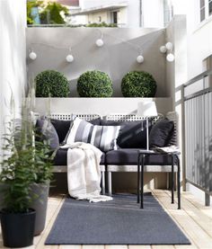 a black and white couch sitting on top of a wooden floor next to potted plants