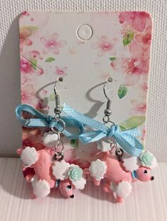 These lovable poodle earrings are hand painted, and bring a bright and cheery mood to your ensemble with pastel pink and blue! 1/4in. tall, weighing less than an ounce. Cute Pink Earrings With Pink Bow, Pink Bow Earrings In Cute Style, Cute Light Blue Earrings Gift, Cute Light Blue Earrings For Gift, Poodle Earrings, Blue Flower Earrings, Pink Poodle, Light Blue Flowers, Pink Pastel