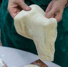 a person kneading dough on top of a table