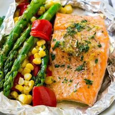 grilled salmon and asparagus on foil with tomatoes, corn and green beans