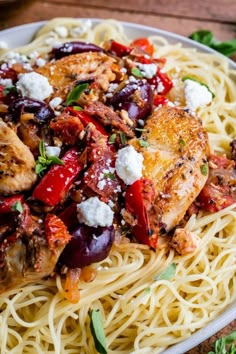 a plate of pasta with chicken, tomatoes and fettuccine