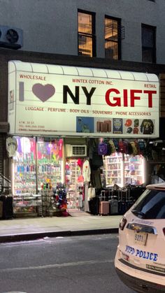 a police car parked in front of a building with a sign that says i love ny gift