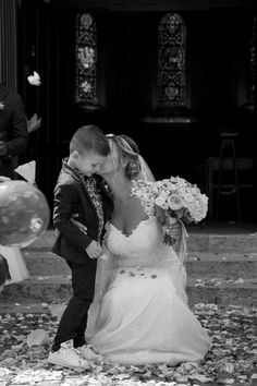 a bride and groom kissing in front of balloons