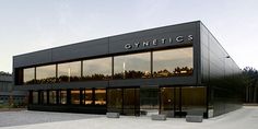 an empty parking lot in front of a building with glass windows and the words gymetics written on it