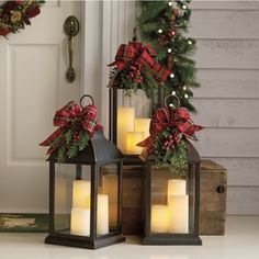 two lanterns with christmas decorations on the front porch