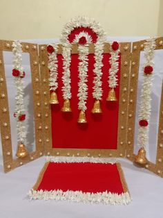 a red and gold decorated stage set with bells, garlands and flowers on it