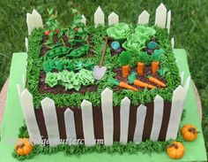 a cake that is shaped like a garden with carrots, lettuce and other vegetables