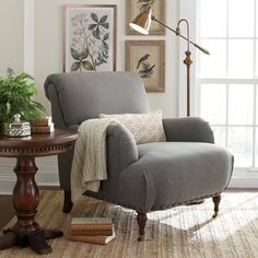 a living room with a chair, table and potted plant