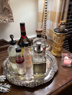 an assortment of liquor bottles and candles on a tray