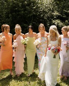 a group of women standing next to each other in dresses