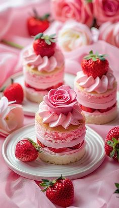 strawberry shortcakes with pink frosting and strawberries on the table next to them