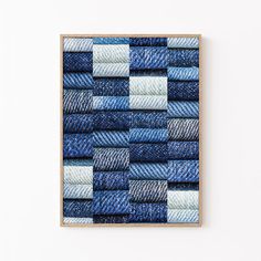 a wooden frame with blue jeans folded in squares