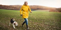 a woman walking her dog in the field