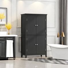 a white tub sitting next to a black cabinet in a bathroom