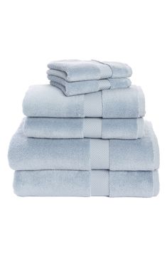 four towels stacked on top of each other in light blue colors with white trims