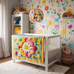 a baby's room with colorful wallpaper and flowers on the walls, including a crib