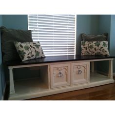 two pillows are sitting on top of a shelf in front of a window with shutters