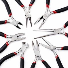 several pairs of pliers are arranged in a circle on a white surface with red and black handles