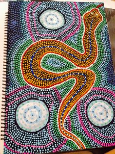 a spiral notebook with an image of a snake on the cover and circles around it