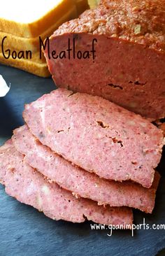 meatloaf is cut into slices on a cutting board with bread in the background