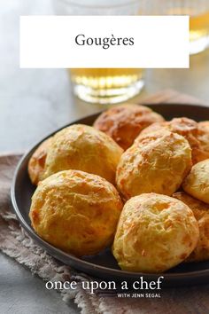 there is a plate full of biscuits on the table with a glass of beer in the background