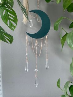 a green crescent hanging from the side of a wall next to a potted plant