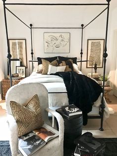 a bedroom with a canopy bed, chair and pictures on the wall above it's headboard