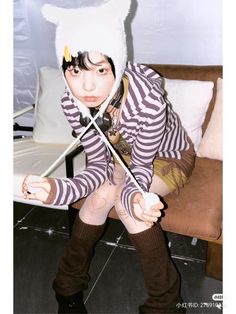 a woman in striped shirt holding two swords