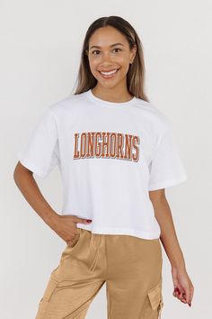 Every day is game day with our Texas Longhorns midi-length, boxy fit cropped tee with drop shoulder sleeves. Perfect for game day excitement or casual outings, this versatile tee is a must-have addition to your wardrobe. White Cropped T-shirt For Sports, Casual White Cropped T-shirt For Sports, White Cotton Cropped T-shirt For Sports, White Cotton Cropped T-shirt, Sporty White Cropped T-shirt With Text Print, White Sporty Cropped T-shirt With Text, White Graphic Print Cropped T-shirt, White Graphic Print Cropped T-shirt Athleisure, White Athleisure Tops For Game Day