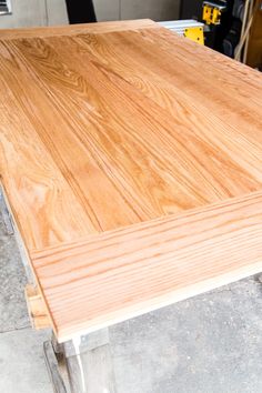 a wooden table with metal legs in a garage