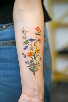 a woman's arm with colorful flowers on the left side of her arm,