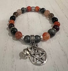 "Happy Halloween and a Blessed Samhain! This beautiful stretch bracelet features a selection of semi precious to aid in communication with the ancestors, increasing intuition, connecting to past, present and future, balance, protection and delving into deep wisdom. Each bracelet will be one of a kind and made to order. A pentacle and tiny cauldron charm set off the bracelet with your choice of antique silver or antique bronze elements. Please know that each bracelet I make is truly one-of-a-kind Spiritual Gemstone Beads Stretch Bracelet For Meditation, Spiritual Stretch Bracelet With Gemstone Beads For Healing, Spiritual Beaded Bracelets With Natural Stones, Spiritual Healing Stretch Bracelet With Gemstone Beads, Adjustable Gemstone Stretch Bracelet For Spiritual Healing, Adjustable Spiritual Stretch Bracelet For Healing, Symbolic Beaded Bracelets With Natural Stones For Meditation, Spiritual Silver Stretch Bracelet With Gemstone, Spiritual Gemstone Beaded Bracelets