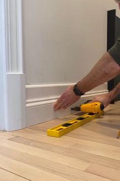 a man laying on the floor with tools in front of him and his hand reaching for something