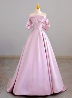 Qaulifying as a masterpiece of elegance, this prom dress features a harmonious blend of timeless beauty and modern sophistication. The soft pink color adds a touch of romance, while the off-shoulder neckline with structured sleeves introduces a contemporary twist. The bodice, expertly tailored, accentuates the waist before flowing into a voluminous skirt that ensures you make a grand entrance. The luxurious fabric and exquisite craftsmanship make this gown a standout choice for any formal event. Perfect for those who want to blend classic elegance with modern design, this dress promises to make your prom night truly magical. Embrace your unique style and grace with this stunning gown that is sure to leave a lasting impression. Puffy Sleeves Dress, Structured Sleeves, Dress With Puffy Sleeves, Spongebob Party, Satin Evening Gown, Satin Ball Gown, Blue Ball Gowns, Voluminous Skirt, Strapless Prom Dress