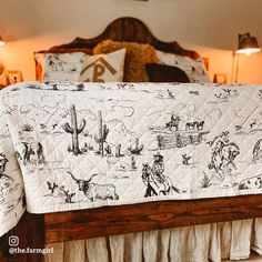 a bed with a white and black bedspread covered in cowboy images on it