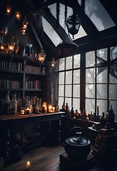 a room filled with lots of books and lit candles in front of a large window