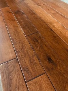 a wooden floor that has been cleaned and is in the process of being polished by someone's hand